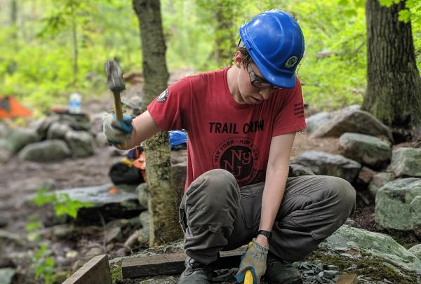 Trail Conference Conservation Corps Palisades Trail Crew member building trails in Sterling Forest State Park. Photo by Tori Finn.